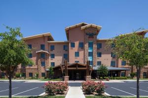 an exterior view of a hotel with a parking lot at TownePlace Suites by Marriott Hobbs in Hobbs