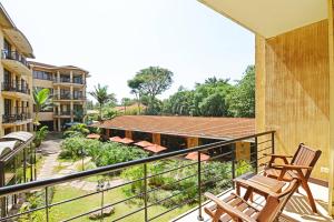 a balcony with two chairs and a view of a building at Protea Hotel by Marriott Kampala in Kampala