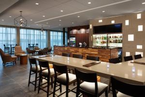 a restaurant with a large table and chairs and a bar at Courtyard by Marriott Winter Haven in Winter Haven