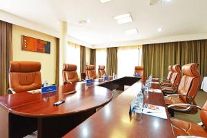 una gran sala de reuniones con una mesa larga y sillas en Protea Hotel by Marriott Kampala en Kampala
