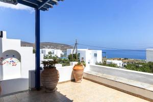 a balcony with two large vases on a white wall at Tinos Beautiful Sunrise Apartment Near Agios Sostis Beach in Agios Sostis