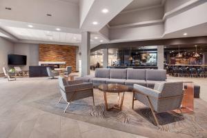 eine Lobby mit einem Sofa, Stühlen und einem Tisch in der Unterkunft Delta Hotels by Marriott Fargo in Fargo
