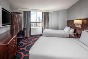 a hotel room with two beds and a flat screen tv at Courtyard by Marriott Boston Downtown in Boston