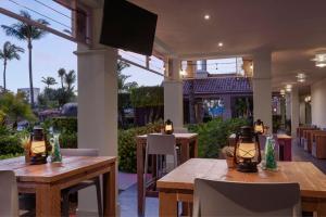 um restaurante com mesas de madeira e uma televisão de ecrã plano em Marriott's Aruba Surf Club em Palm-Eagle Beach