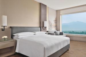 a bedroom with a large white bed and a large window at Kathmandu Marriott Hotel in Kathmandu