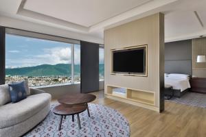 a living room with a couch and a tv at Kathmandu Marriott Hotel in Kathmandu