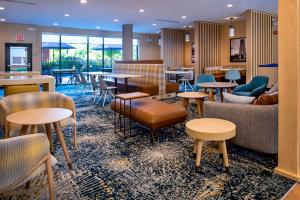 a lobby with tables and chairs and a bar at TownePlace Suites by Marriott Frederick in Frederick