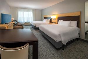 フレデリックにあるTownePlace Suites by Marriott Frederickのベッド2台とデスクが備わるホテルルームです。