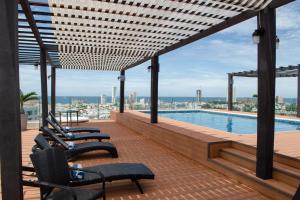 a patio with chairs and a swimming pool on a building at Four Points by Sheraton Veracruz in Veracruz