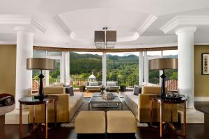 a living room with couches and a large window at Penha Longa Resort in Sintra