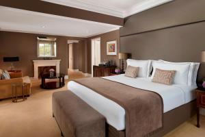 a large bedroom with a large bed and a living room at Penha Longa Resort in Sintra