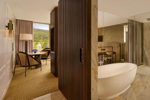 a bathroom with a tub and a sink in a room at Penha Longa Resort in Sintra