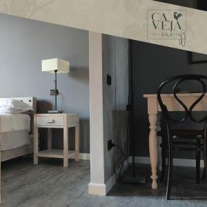 a bedroom with a bed and a desk and a chair at Ca Veja B&B Forlì in Forlì