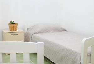 a white bedroom with a white bed and a table at Old town boulevard apartment in city center in Durrës