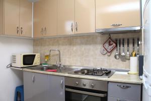 una cucina con lavandino e forno a microonde di Old town boulevard apartment in city center a Durrës