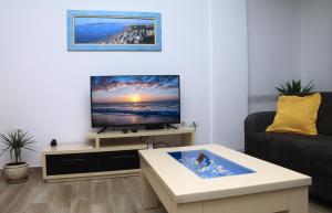 sala de estar con TV y sofá en Old town boulevard apartment in city center en Durrës