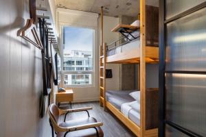 a small room with a bunk bed and a chair at Moxy Washington, DC Downtown in Washington