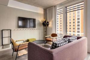 a living room with a couch and a large window at Moxy Washington, DC Downtown in Washington