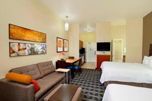 a hotel room with a couch and a bed at TownePlace Suites St. George in St. George