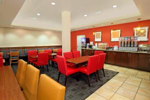 um restaurante com cadeiras vermelhas, uma mesa e um bar em TownePlace Suites St. George em St. George