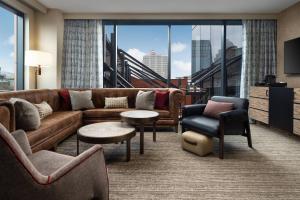 a living room with a couch and chairs and a large window at Hotel Distil, Autograph Collection in Louisville
