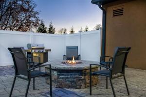 a patio with a table and chairs with a fire pit at Fairfield Inn & Suites by Marriott Cortland in Cortland