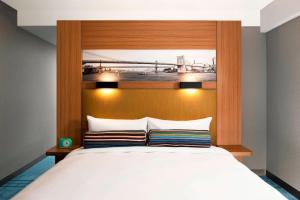 a bedroom with a large bed with a wooden headboard at Aloft Brooklyn in Brooklyn