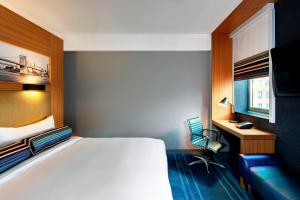 a bedroom with a bed and a desk and a chair at Aloft Brooklyn in Brooklyn