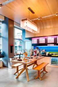a kitchen with a large wooden table and benches at Aloft Brooklyn in Brooklyn