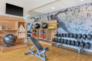 a room with a gym with a chair and weights at Sheraton Tarrytown Hotel in Tarrytown