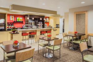 a restaurant with tables and chairs and a kitchen at TownePlace Suites Houston Northwest in Houston