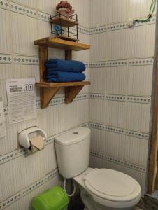 a bathroom with a toilet and some blue towels at Perezoso Hostel in Rurrenabaque