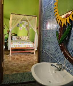ein Bad mit einem Waschbecken und ein Bett in einem Zimmer in der Unterkunft Perezoso Hostel in Rurrenabaque