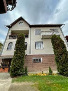 a large house with bushes in front of it at Sadyba Girske Povitria in Yaremche