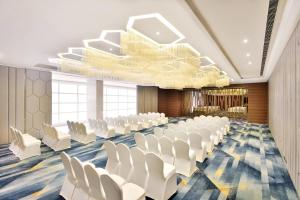 sala konferencyjna z białymi krzesłami i żyrandolem w obiekcie Fairfield by Marriott Indore w mieście Indore