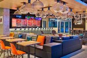 a restaurant with tables and chairs and chandeliers at Aloft Miami Airport in Miami