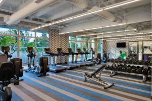 a gym with rows of treadmills and machines at Aloft Miami Airport in Miami