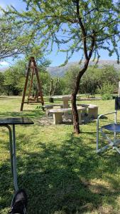 un grupo de mesas de picnic y un árbol en un campo en Anan en Cortaderas