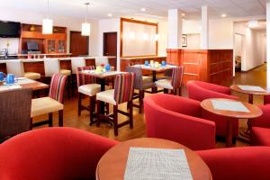 a restaurant with red chairs and tables and tablesktop at Four Points by Sheraton Houston Hobby Airport in Houston