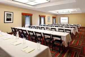 a conference room with tables and chairs and a screen at Four Points by Sheraton Houston Hobby Airport in Houston