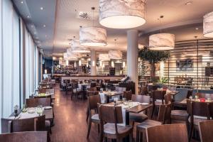 a restaurant with tables and chairs and a bar at Courtyard by Marriott Munich City Center in Munich