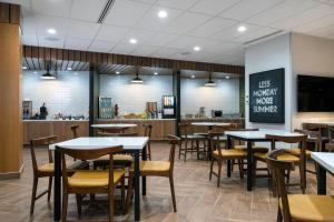 a restaurant with tables and chairs and a counter at Fairfield by Marriott Inn & Suites North Bay in North Bay
