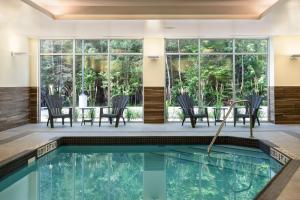 a pool in a house with chairs and a table at Fairfield by Marriott Inn & Suites North Bay in North Bay