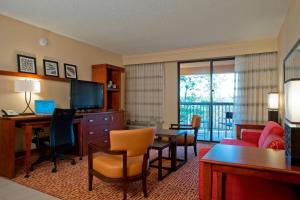 a hotel room with a desk and a living room at Courtyard Gulf Shores Craft Farms in Gulf Shores