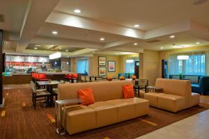 a lobby with two couches and a dining room and a restaurant at Courtyard Gulf Shores Craft Farms in Gulf Shores