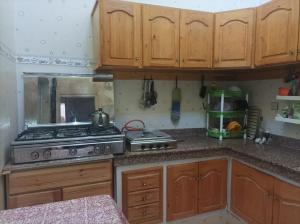 a kitchen with wooden cabinets and a stove at Maison Latifa in Oujda
