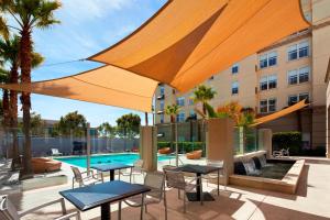 a patio with tables and chairs and a pool at Aloft Silicon Valley in Newark