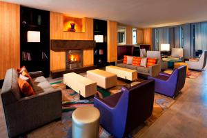 a living room with couches and a fireplace at Aloft Silicon Valley in Newark