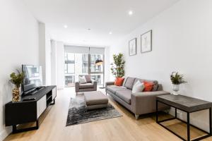 a living room with a couch and a tv at Khayat Homes - The Owelor - Two Bed in London