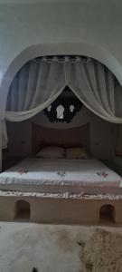 a bedroom with a bed with a canopy at Typique appartement in Houmt Souk